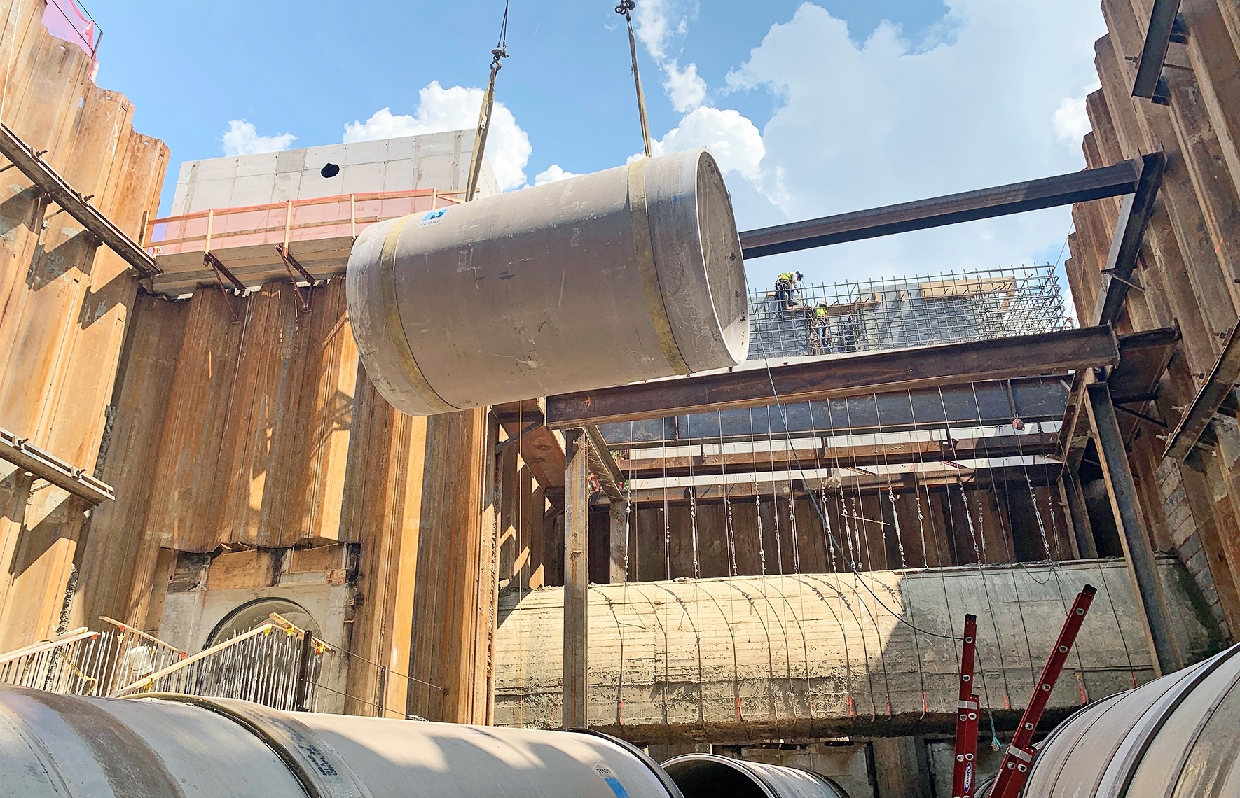 Here, our team is lowering a tie-in section of 84" Hobas pipe into place on the Mill Creek HRT Diversion Chamber Design-Build. These pipes transfer sewage flow from the new Connector Boxes in the background of the image to the Diversion Chamber.